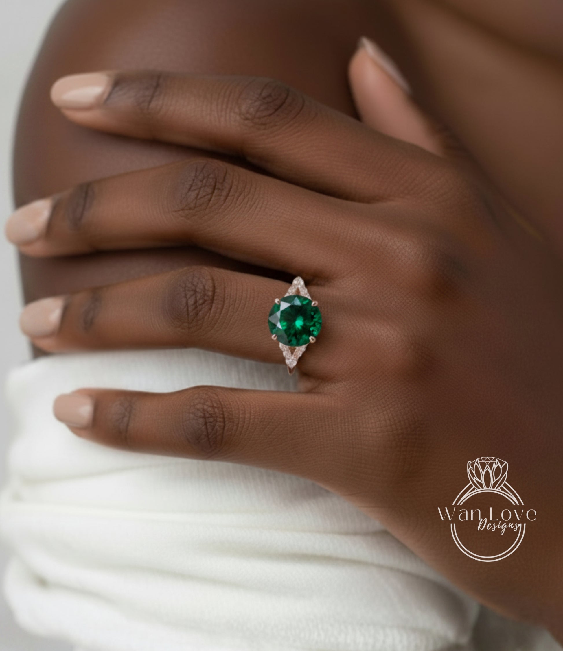 A close-up of a person's hand wearing a ring with a large, green gemstone.