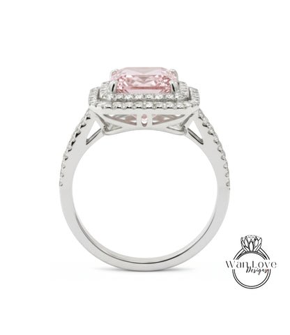 A silver ring with a large pink gemstone, likely a diamond, set in the center.