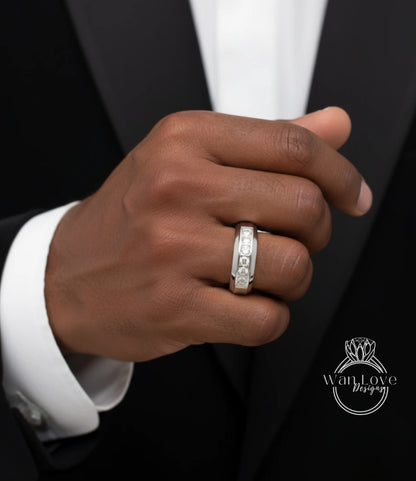 A close-up of a person's hand wearing a silver ring with a diamond band.