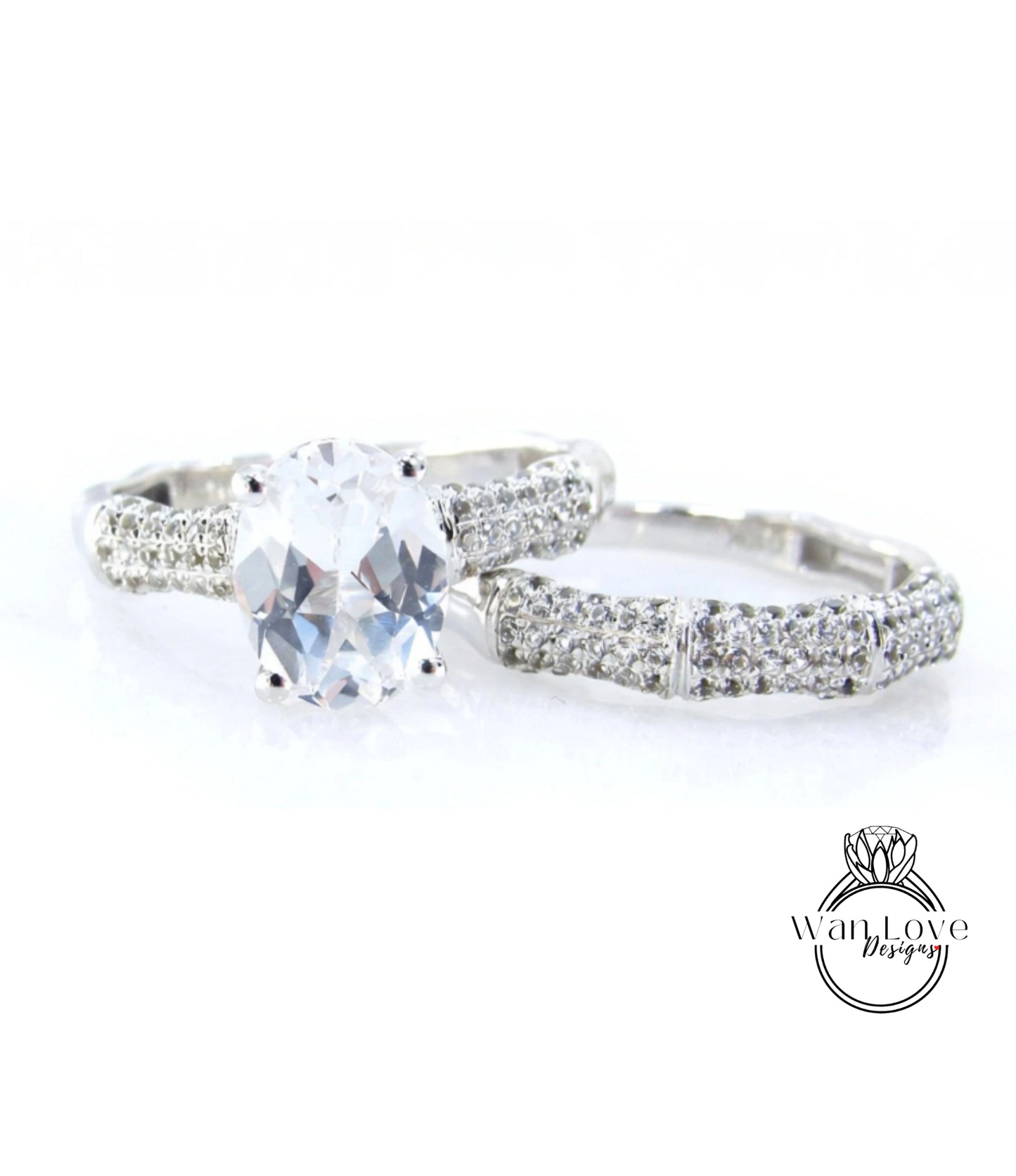 A close-up view of a diamond engagement ring with a large oval-shaped diamond set in a silver band adorned with small diamonds.