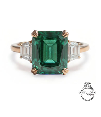 A large, green gemstone ring with a gold band and three smaller diamonds on either side.