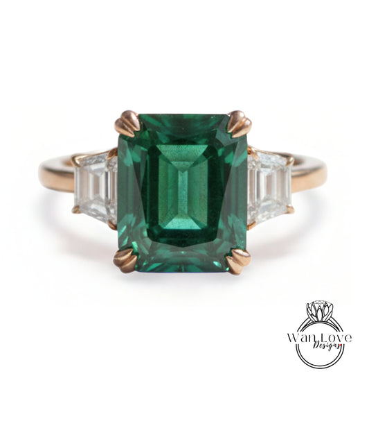A large, green gemstone ring with a gold band and three smaller diamonds on either side.