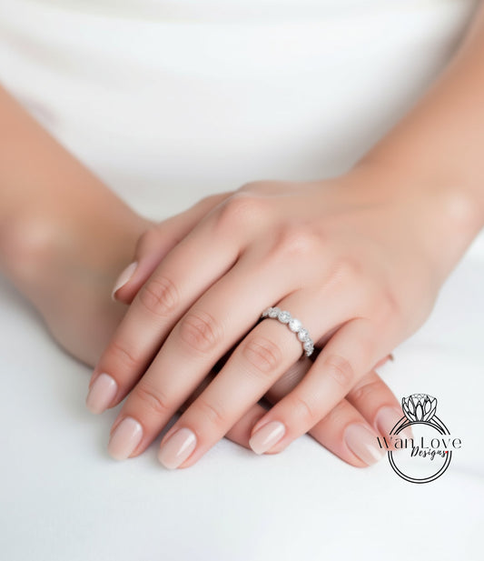A close-up of a person's hands wearing a diamond ring on the ring finger.