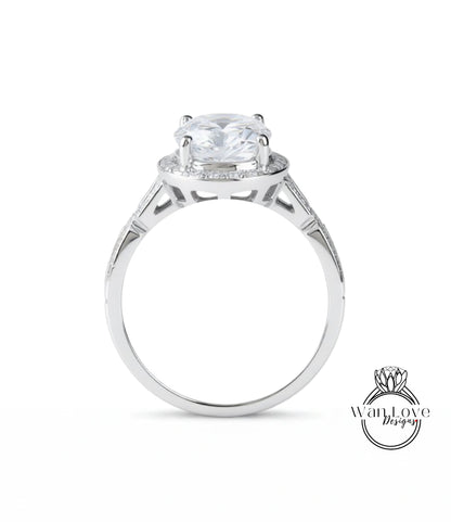 A silver engagement ring with a large central diamond surrounded by smaller diamonds.