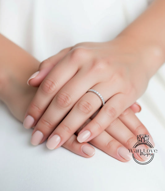 A close-up image of a person's hands with a diamond ring on the ring finger.
