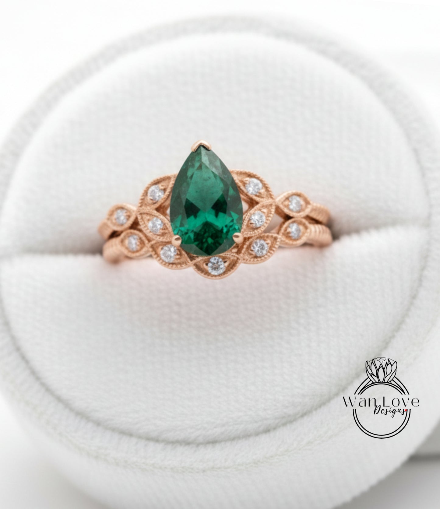 A gold ring with a large green gemstone, possibly a pear-shaped emerald, set in a decorative band.