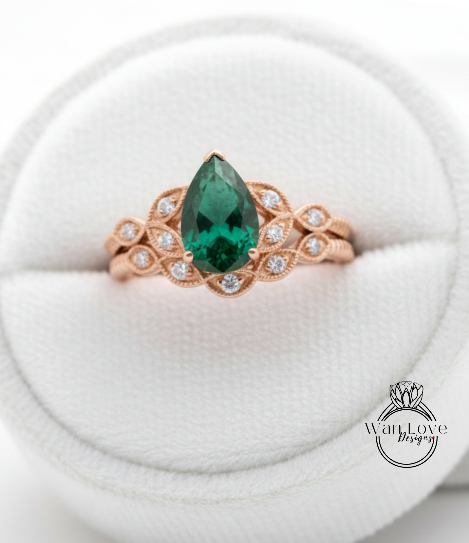 A gold ring with a large green gemstone, possibly a pear-shaped emerald, set in a decorative band.