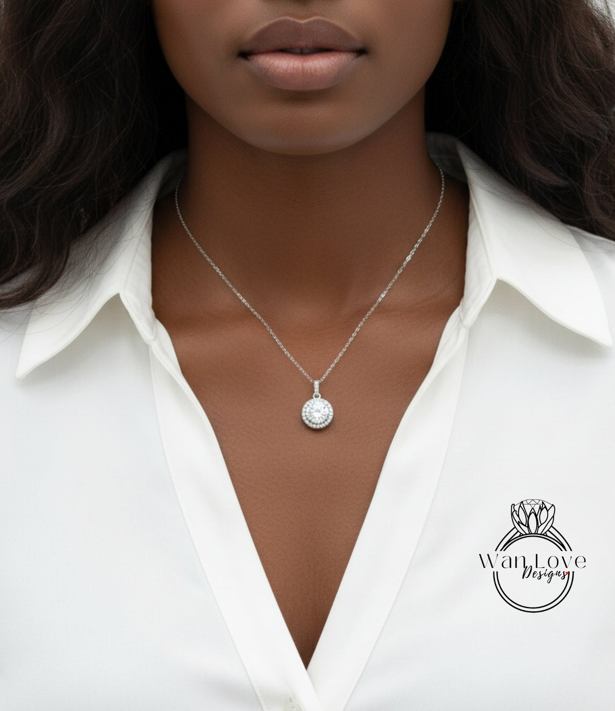 A close-up of a woman wearing a white blouse and a necklace with a pendant.