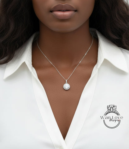 A close-up of a woman wearing a white blouse and a necklace with a pendant.