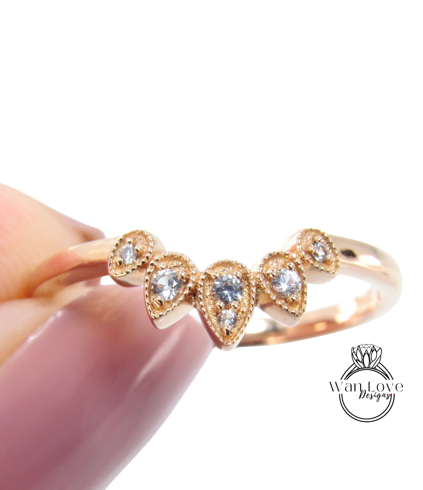 A close-up image of a gold ring with a decorative band featuring a group of small, clear gemstones.