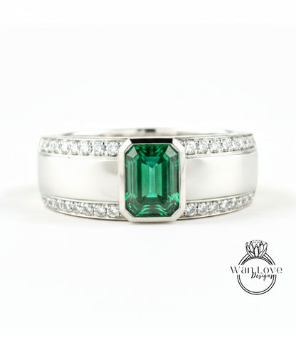 A silver ring with a large green gemstone in the center, surrounded by smaller diamonds.