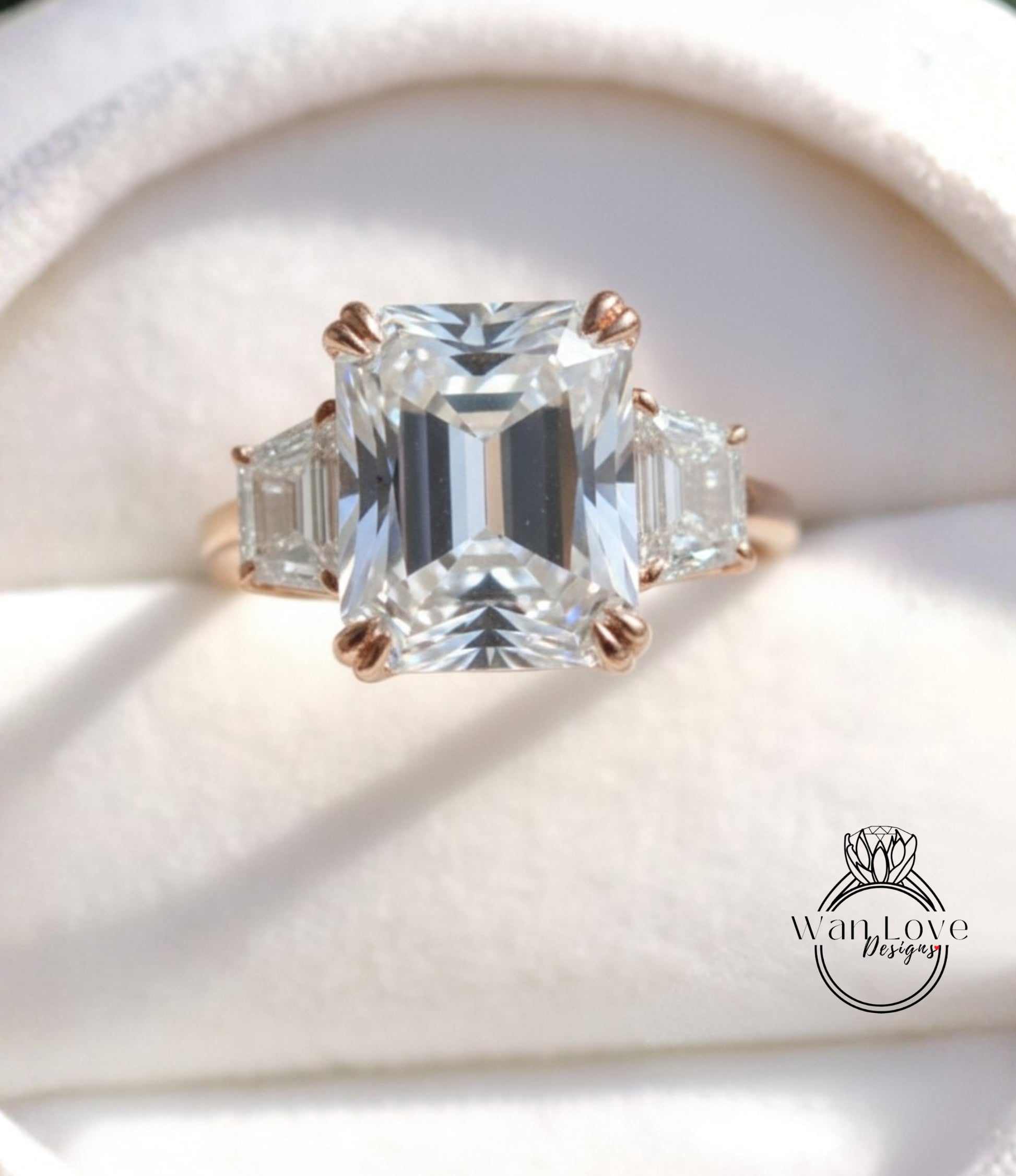 A close-up image of a large, clear diamond engagement ring with a large central diamond surrounded by smaller diamonds on either side.