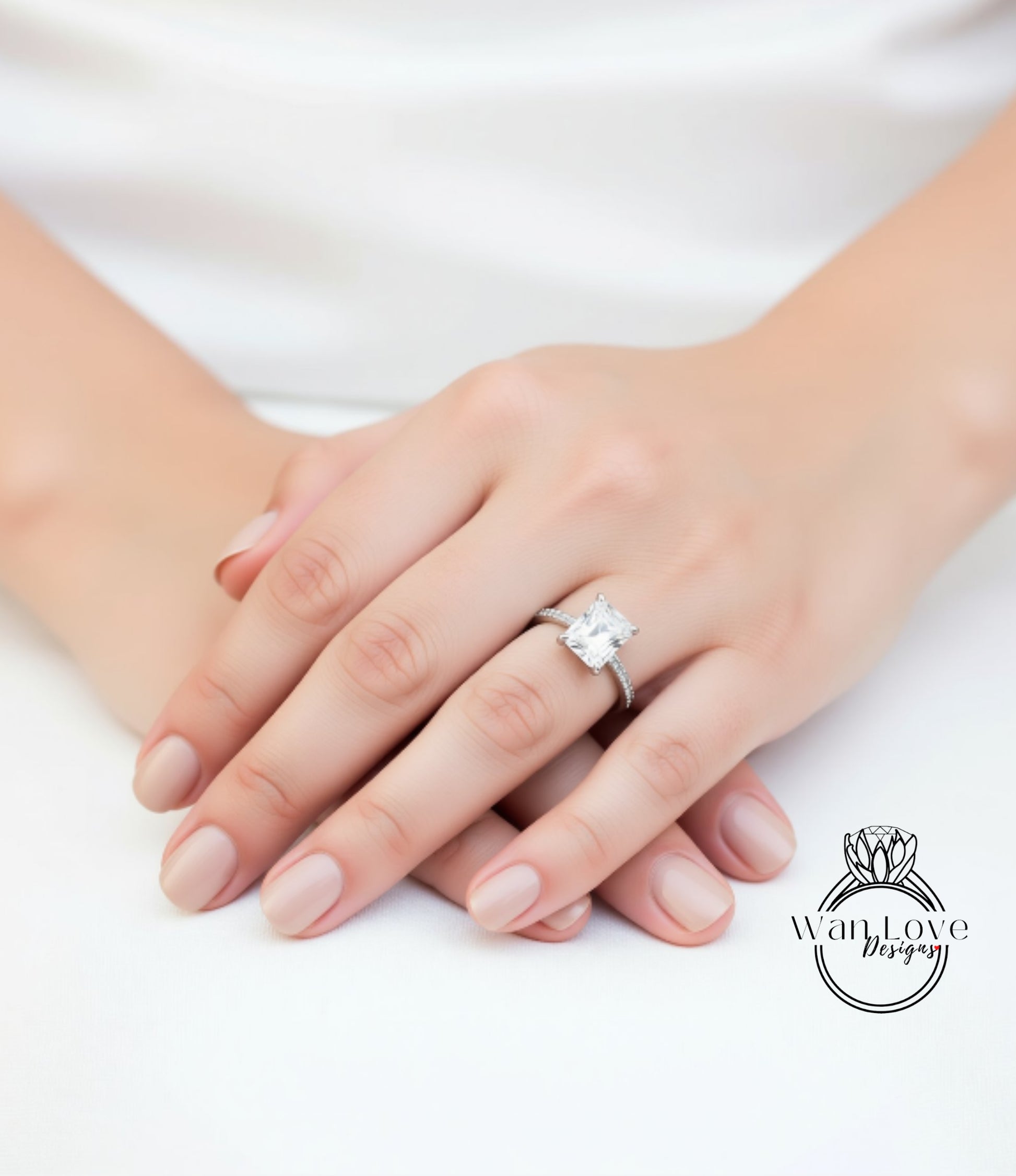 A close-up of a person's hands wearing a diamond engagement ring.