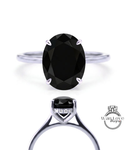 A close-up view of a silver ring with a large oval-shaped black gemstone, showcasing the intricate design and craftsmanship of the piece.