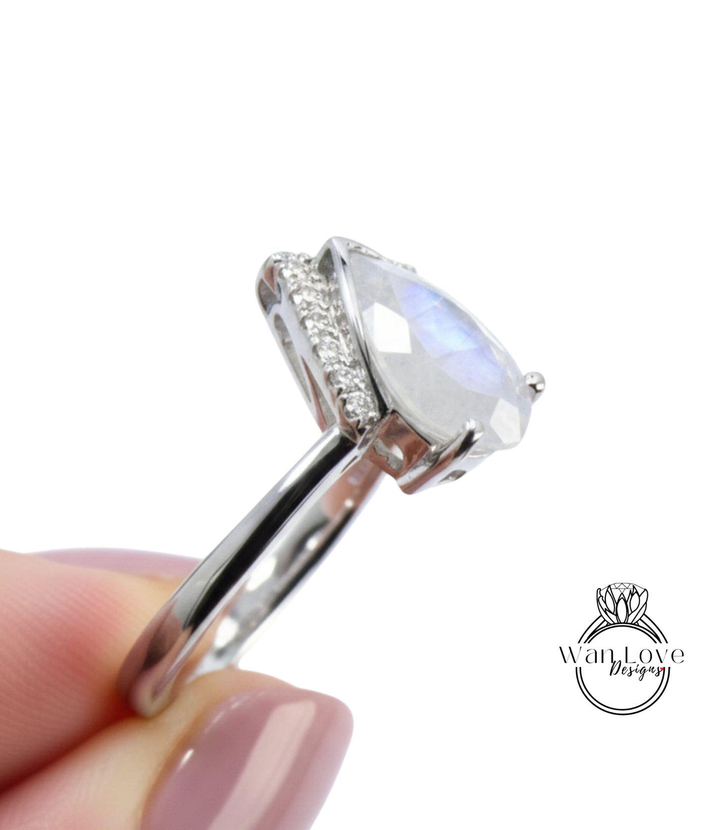 A close-up image of a person's hand holding a silver ring with a large, clear gemstone, likely a diamond, on the ring finger.