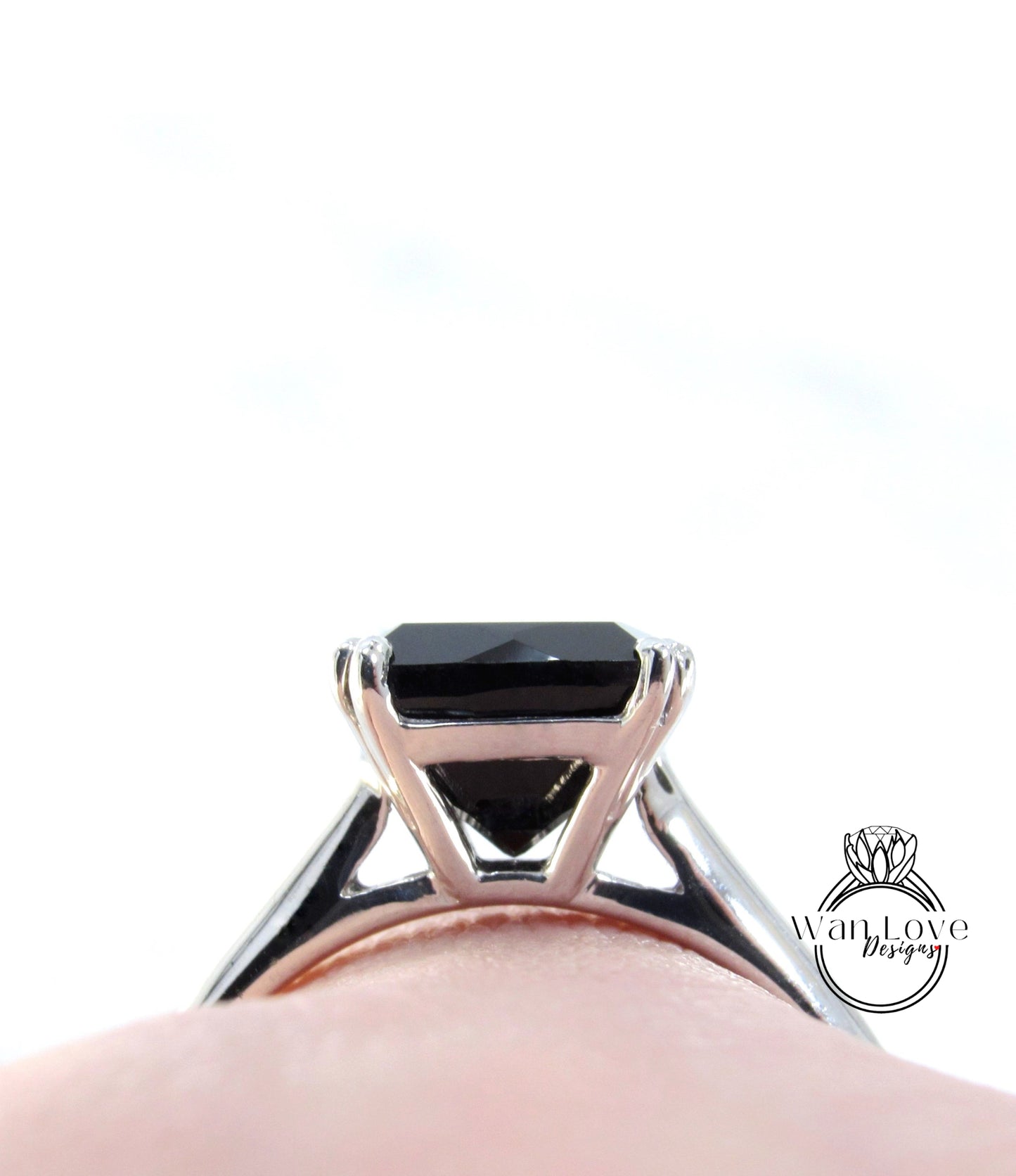 A close-up view of a silver ring with a large black gemstone, possibly a diamond, set in the center.