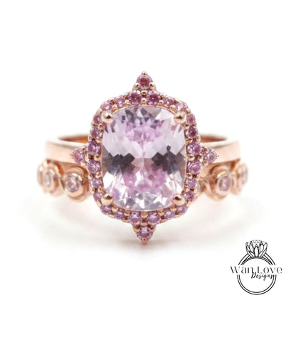 a beautiful pink gemstone ring with a large central gemstone surrounded by smaller gemstones.