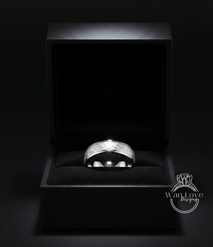 A silver ring is displayed in a black jewelry box against a dark background.