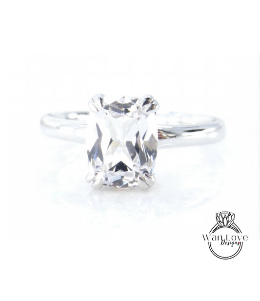 A close-up view of a diamond engagement ring with a large, clear gemstone set in a silver band.