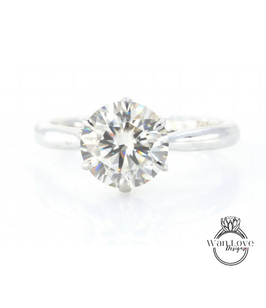 A close-up view of a diamond engagement ring with a large, brilliant-cut diamond set in a silver band.