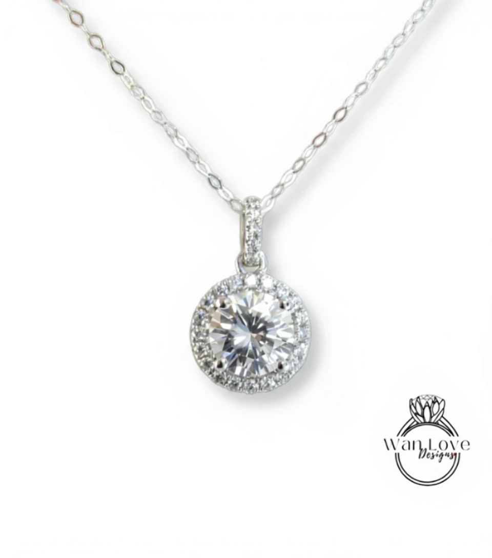 A close-up view of a delicate necklace with a large, round diamond pendant.