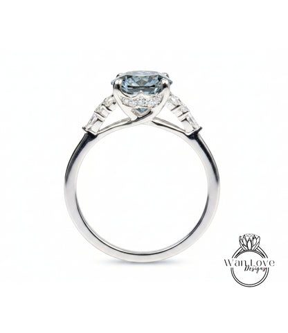 A silver engagement ring with a large blue gemstone set in the center, surrounded by smaller diamonds.