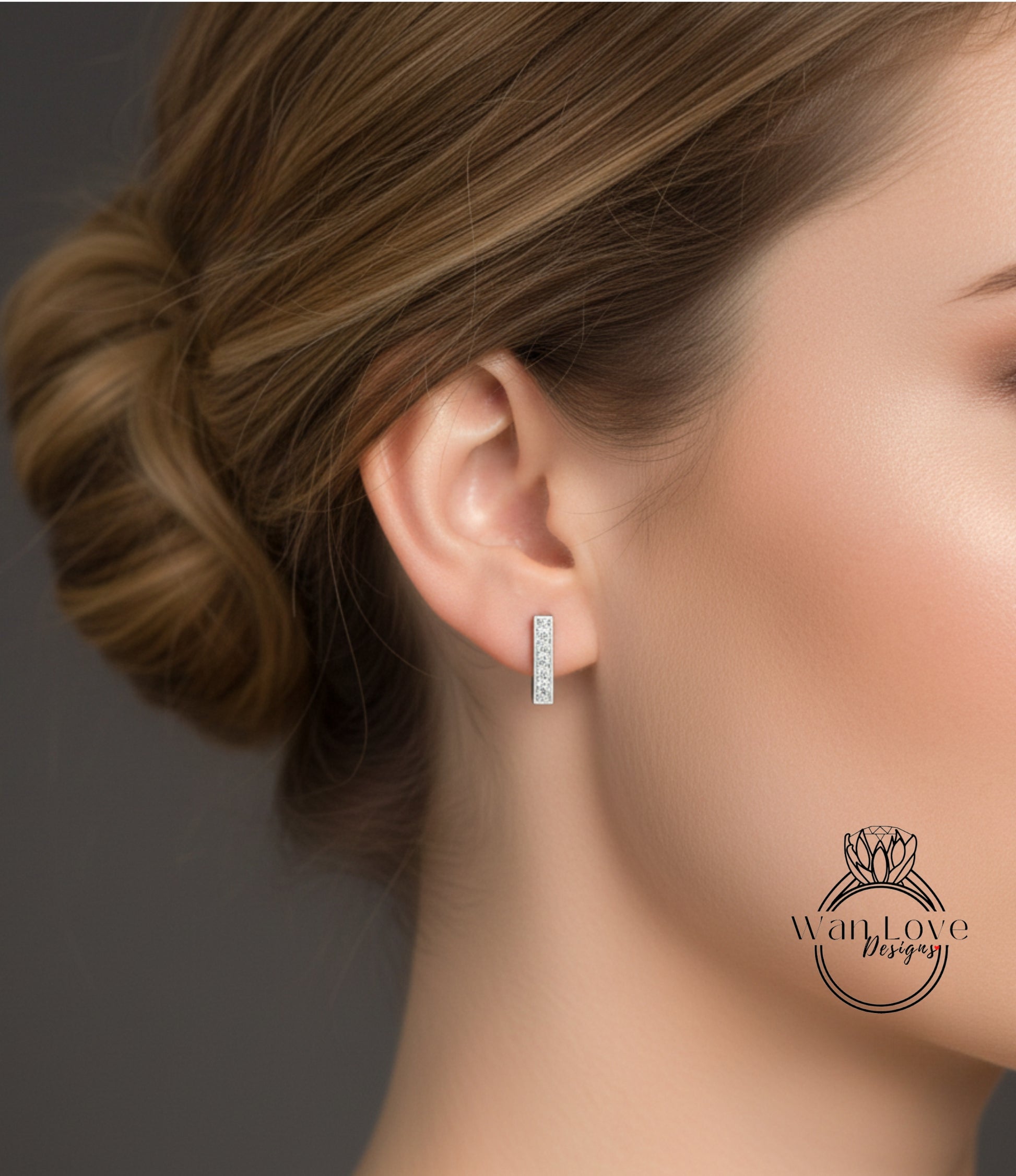 A close-up of a woman's ear with a diamond earring, showcasing the earring and the woman's hair.