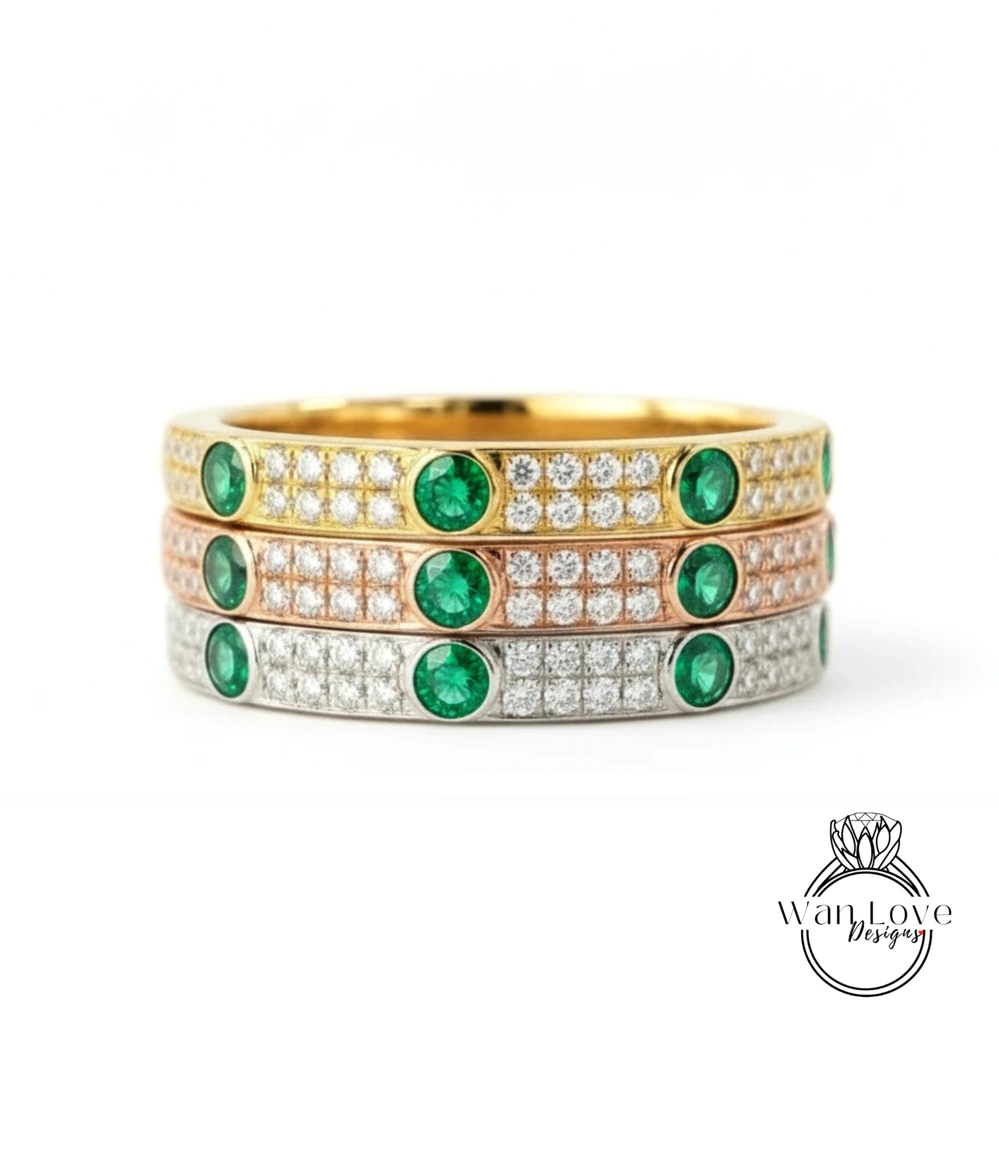 A stack of three rings with green gemstones and diamonds set in gold and silver.