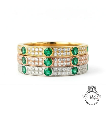 A stack of three rings with green gemstones and diamonds set in gold and silver.