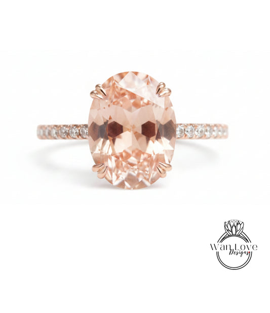 A rose gold ring with a large oval-shaped gemstone set in the center, surrounded by smaller diamonds.