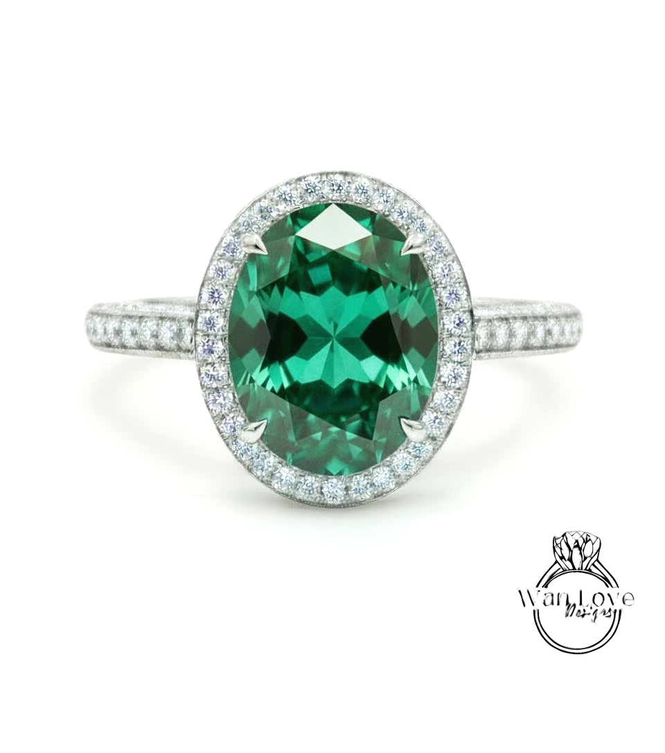 A stunning ring featuring a large oval-shaped green gemstone surrounded by a halo of smaller diamonds set in a silver band.