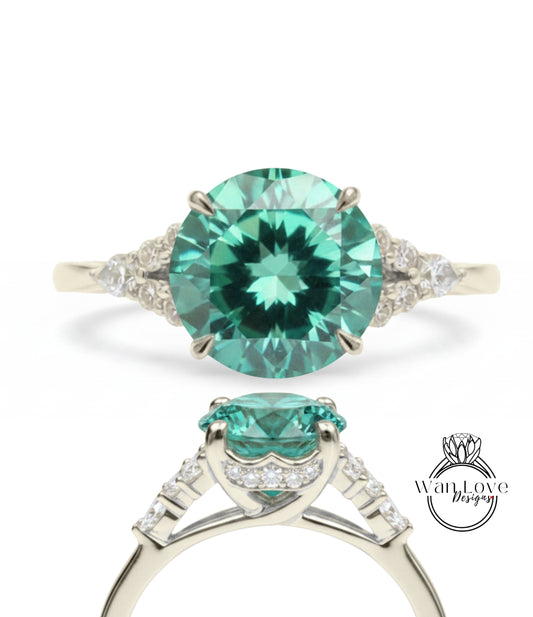 A close-up view of a diamond engagement ring with a large, round green gemstone set in a silver band.