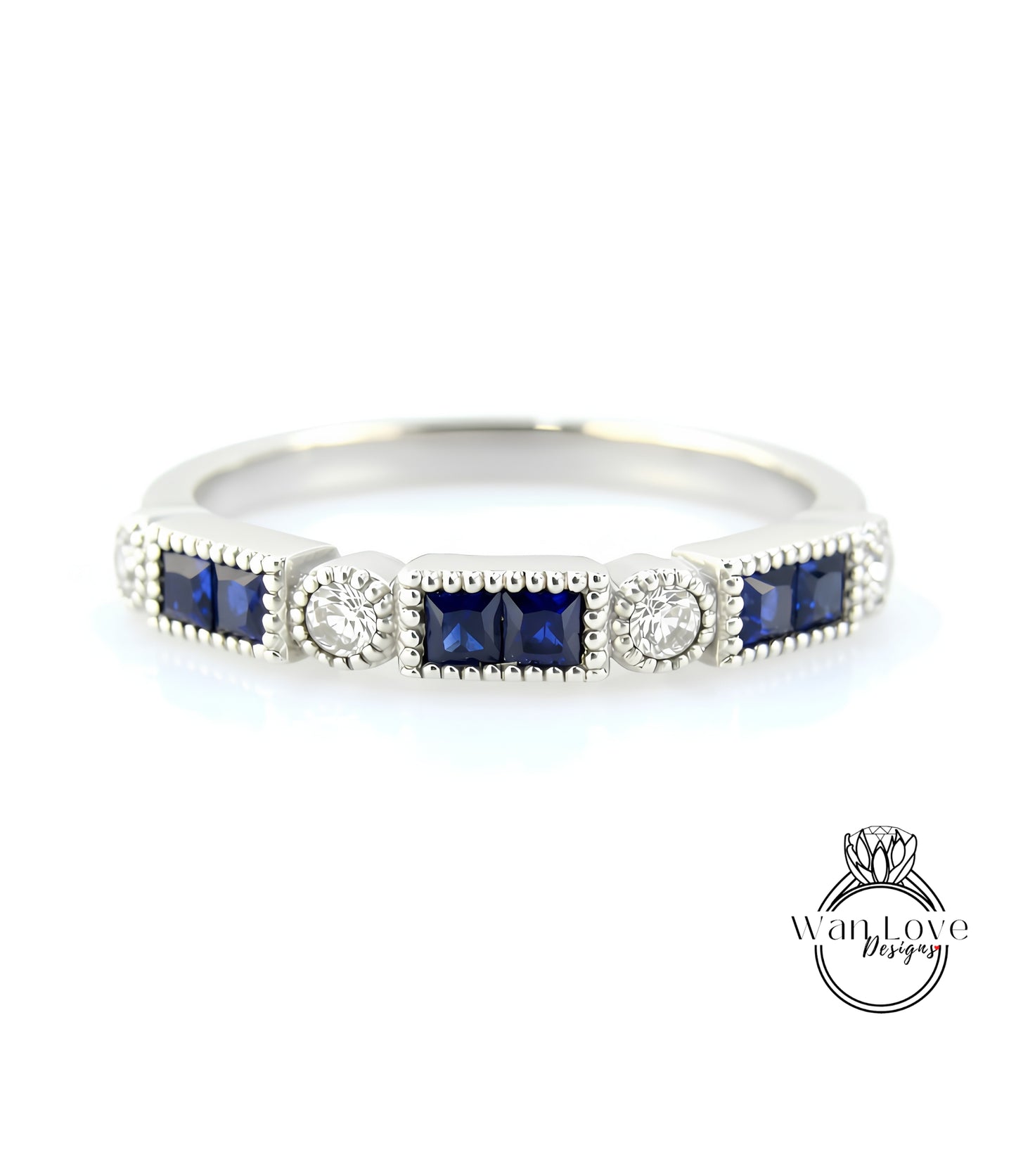 A silver ring with a row of blue gemstones, including diamonds, set in a decorative pattern.