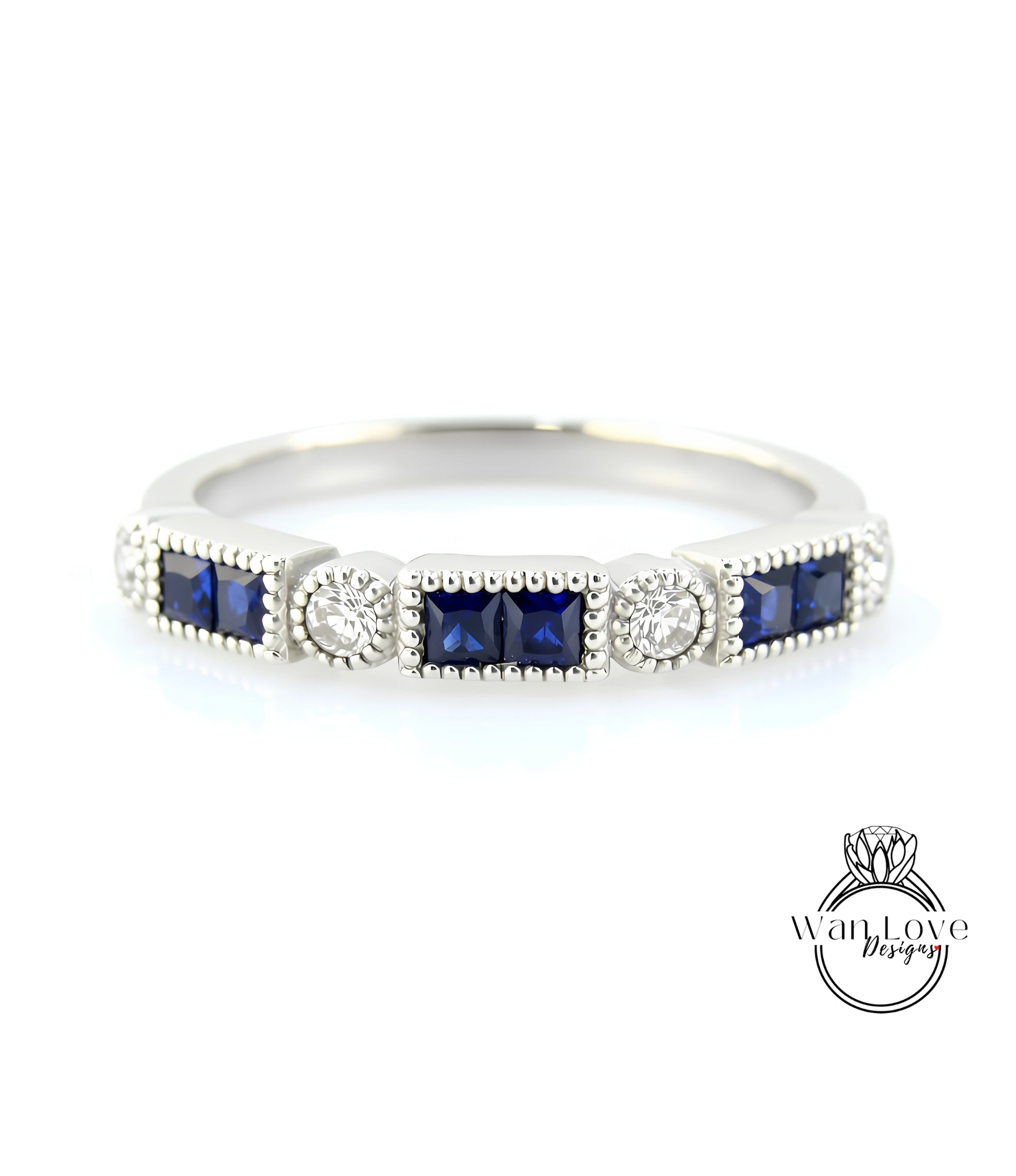 A silver ring with a row of blue gemstones, including diamonds, set in a decorative pattern.