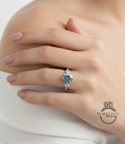 A close-up of a person's hand wearing a diamond engagement ring.