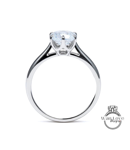 A silver engagement ring with a large, clear gemstone set in the center of the band.