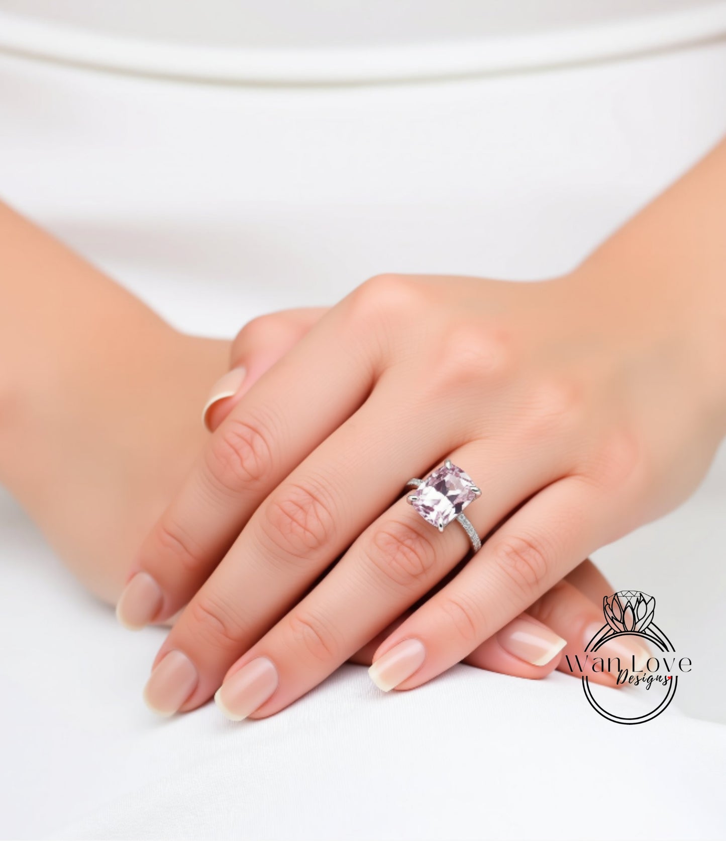 A close-up of a person's hand wearing a large, pink gemstone ring.