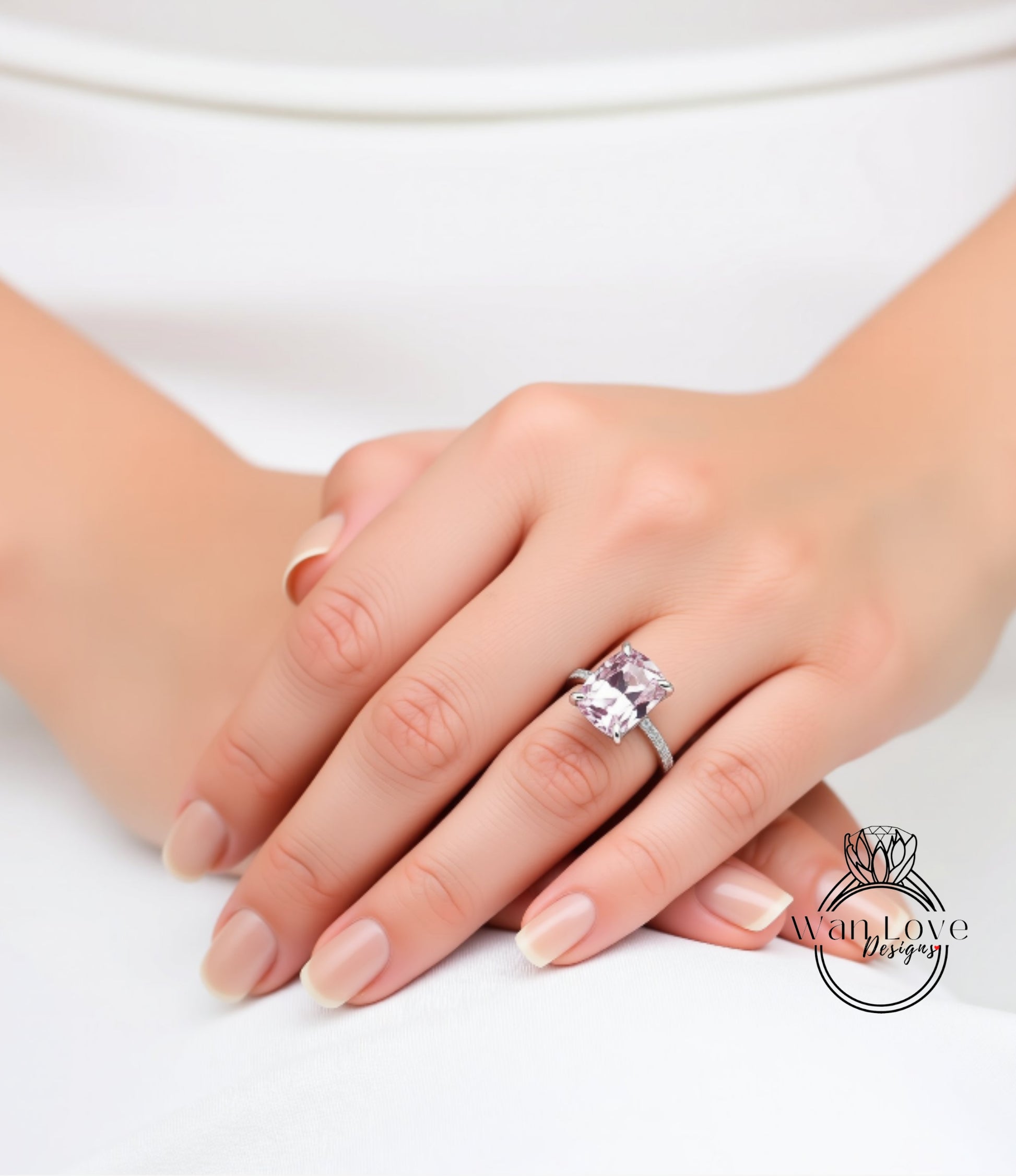 A close-up of a person's hand wearing a large, pink gemstone ring.