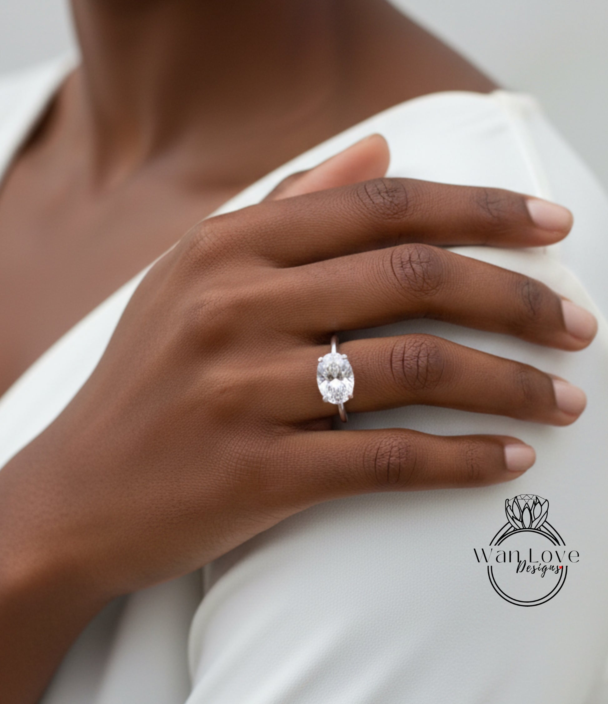 A close-up of a person's hand wearing a large diamond engagement ring.