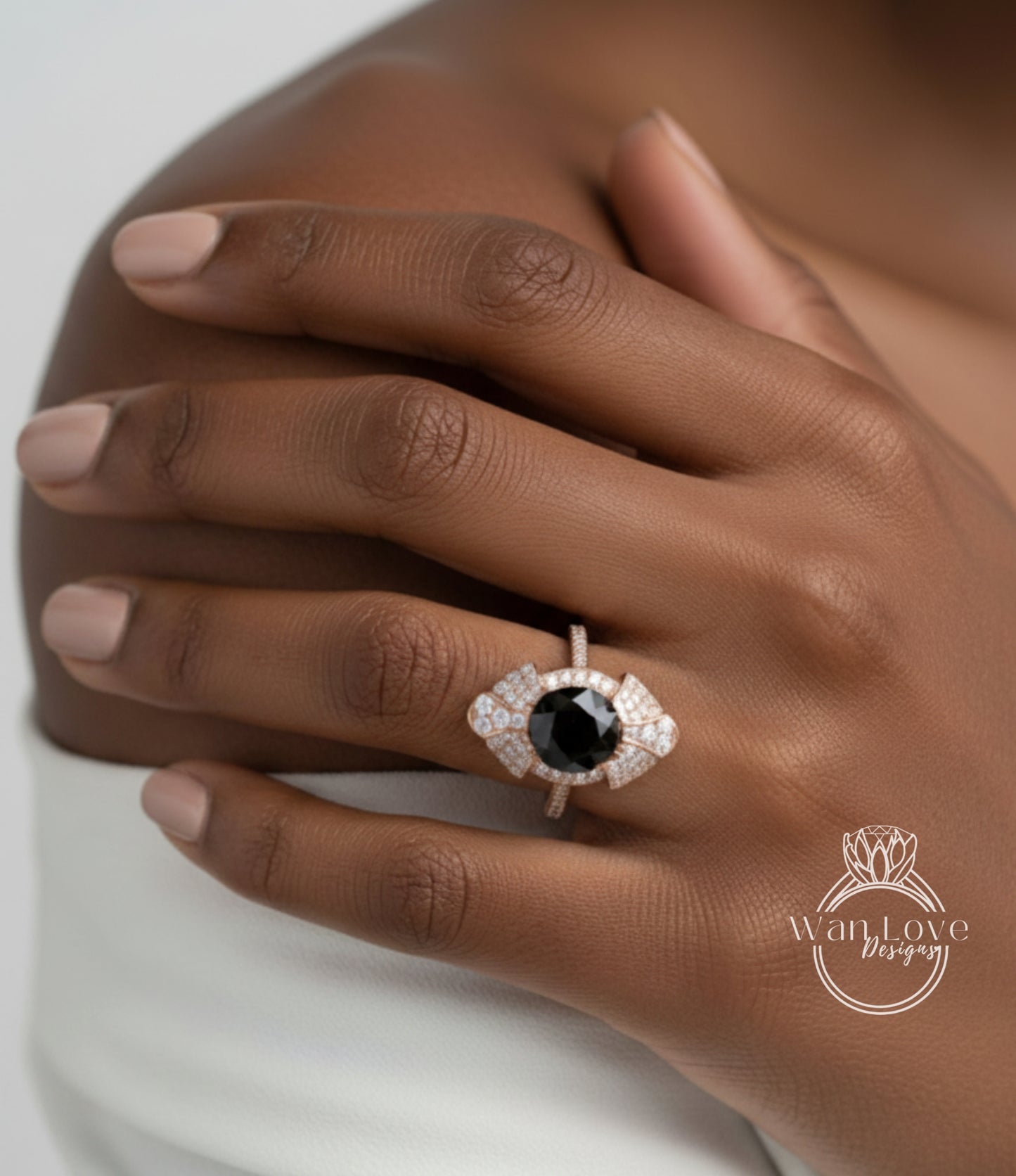 A close-up of a person's hand wearing a ring with a large black gemstone, likely a diamond, surrounded by smaller diamonds.