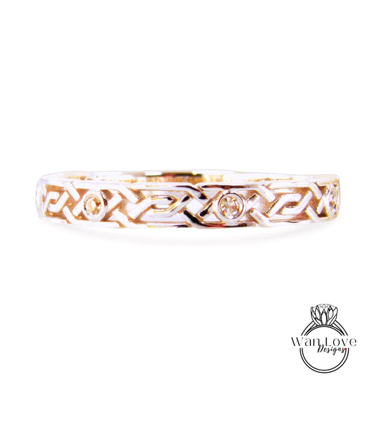 A silver ring with an intricate design featuring two small diamonds.