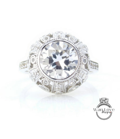 A large, round diamond ring with a halo of smaller diamonds around the center stone.