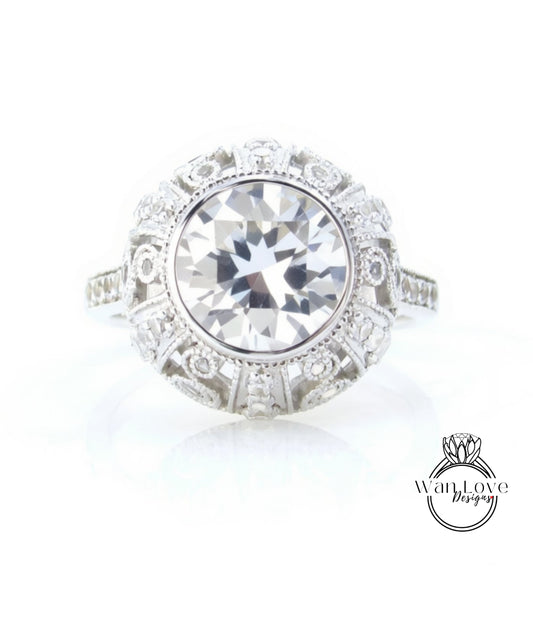 A large, round diamond ring with a halo of smaller diamonds around the center stone.