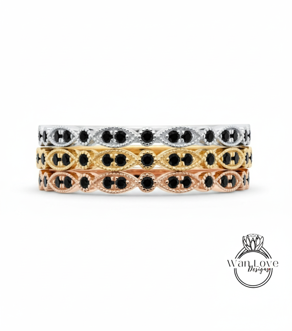 A stack of three rings with black gemstones set in a decorative pattern.
