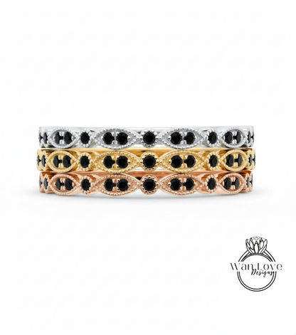 A stack of three rings with black gemstones set in a decorative pattern.
