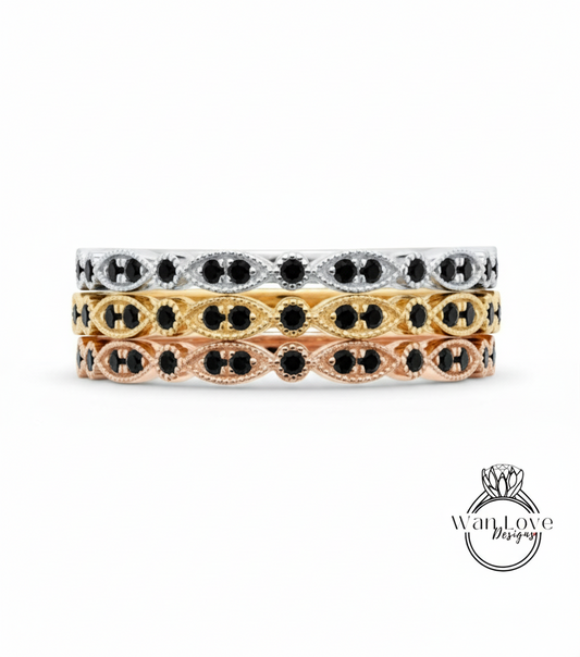 A stack of three rings with black gemstones set in a decorative pattern.