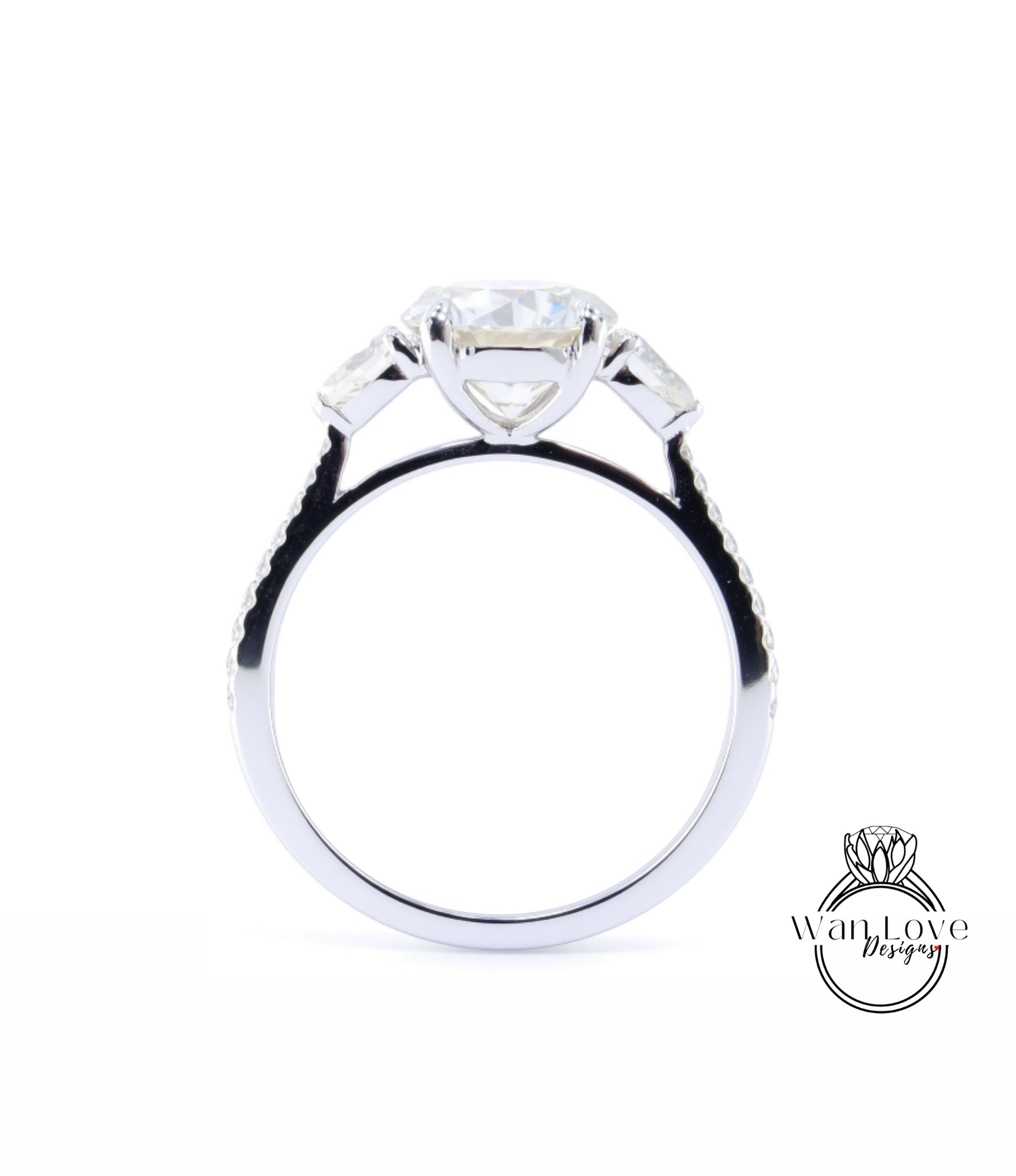 A close-up view of a silver engagement ring with a large central diamond and three smaller diamonds on either side.