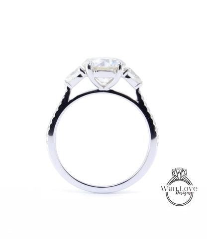A close-up view of a silver engagement ring with a large central diamond and three smaller diamonds on either side.