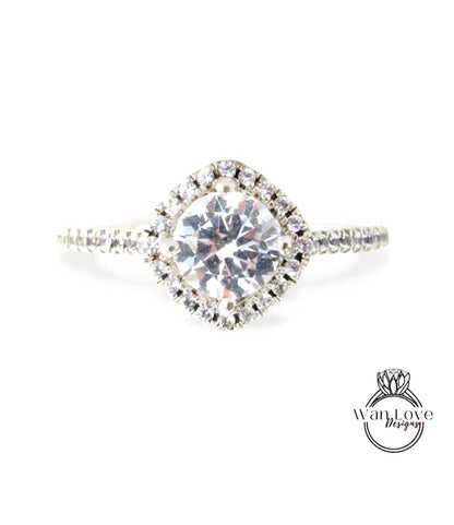 A diamond engagement ring with a large central diamond surrounded by smaller diamonds set in a halo of smaller diamonds.
