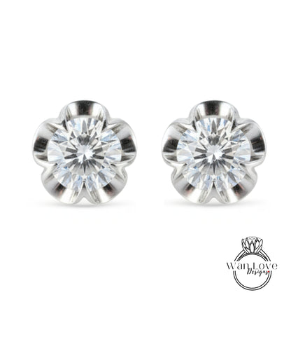 A pair of elegant silver earrings with a large, clear gemstone set in a flower-shaped design.